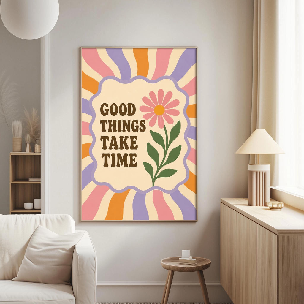 a poster with the text "GOOD THINGS TAKE TIME" and a flower design, hanging on a wall in a living room.
