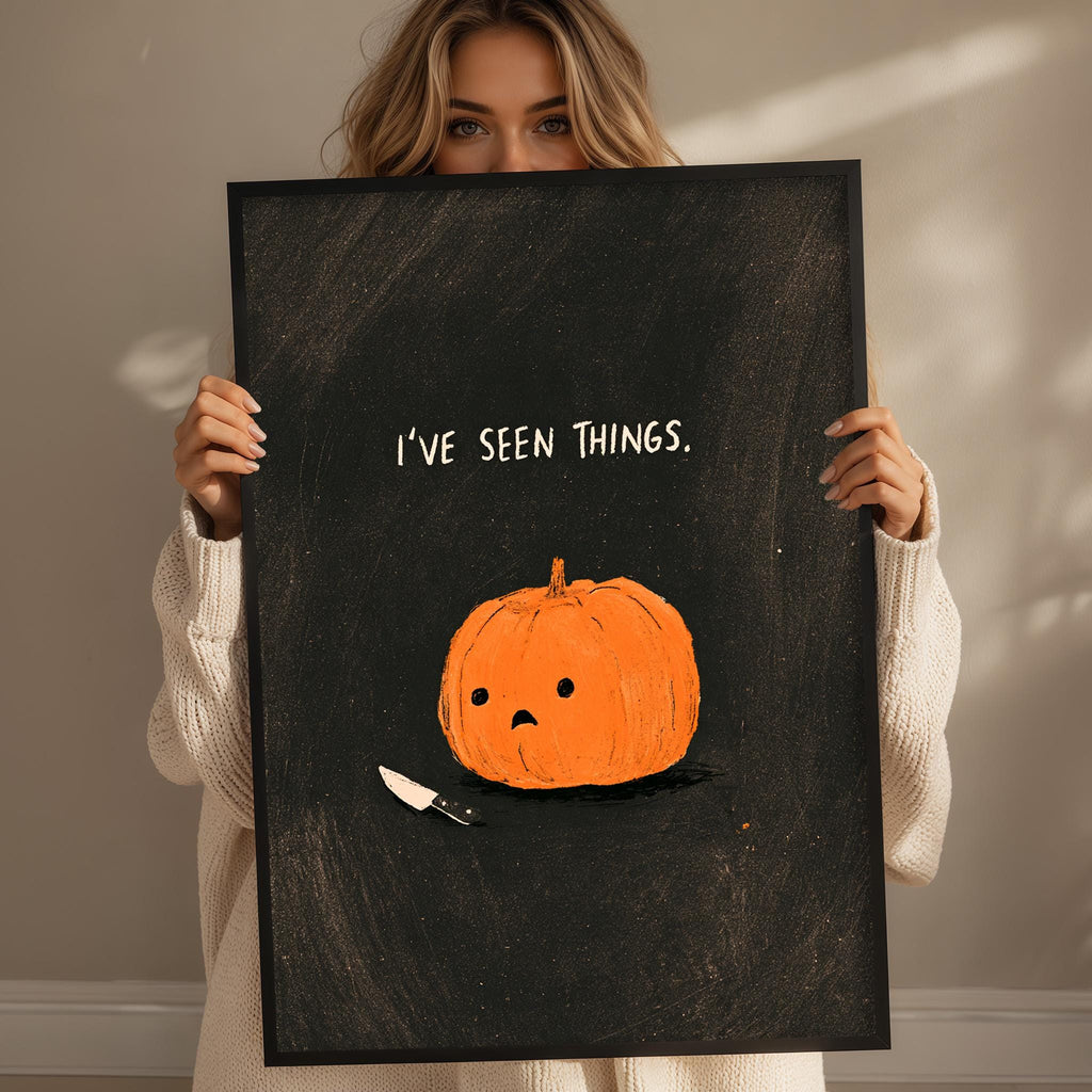 A woman holds up a black poster with an illustration of a pumpkin and a knife, accompanied by the text "I've seen things."