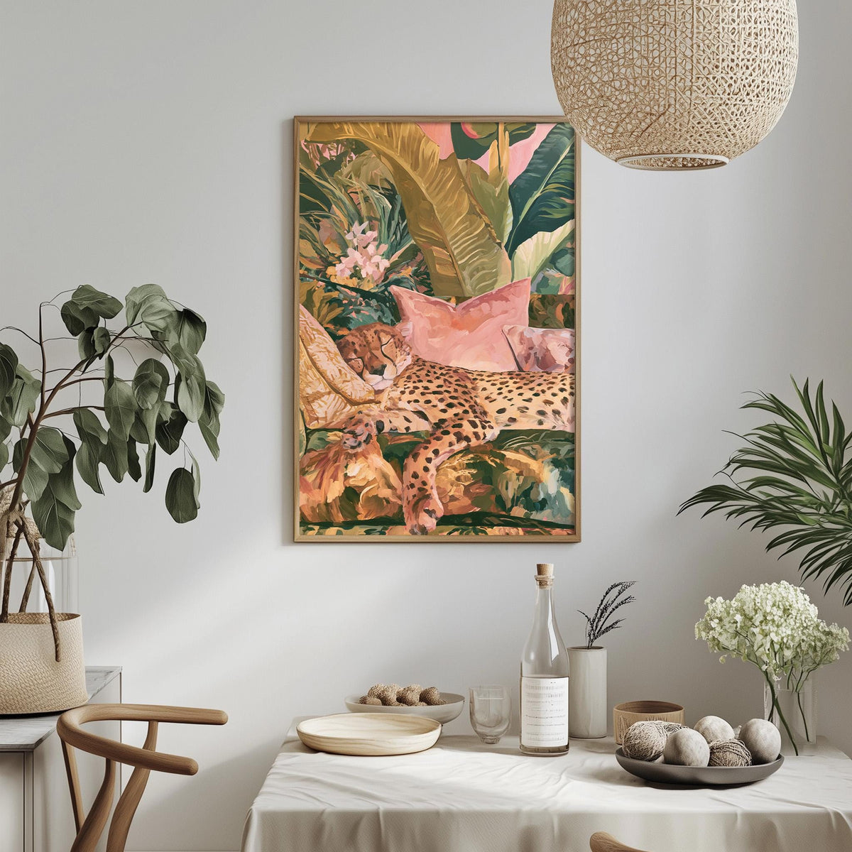 a dining table with a white tablecloth, a vase of white flowers, a bottle, and a bowl of fruit. Above the table, there is a framed painting of a leopard resting on a bed of flowers.