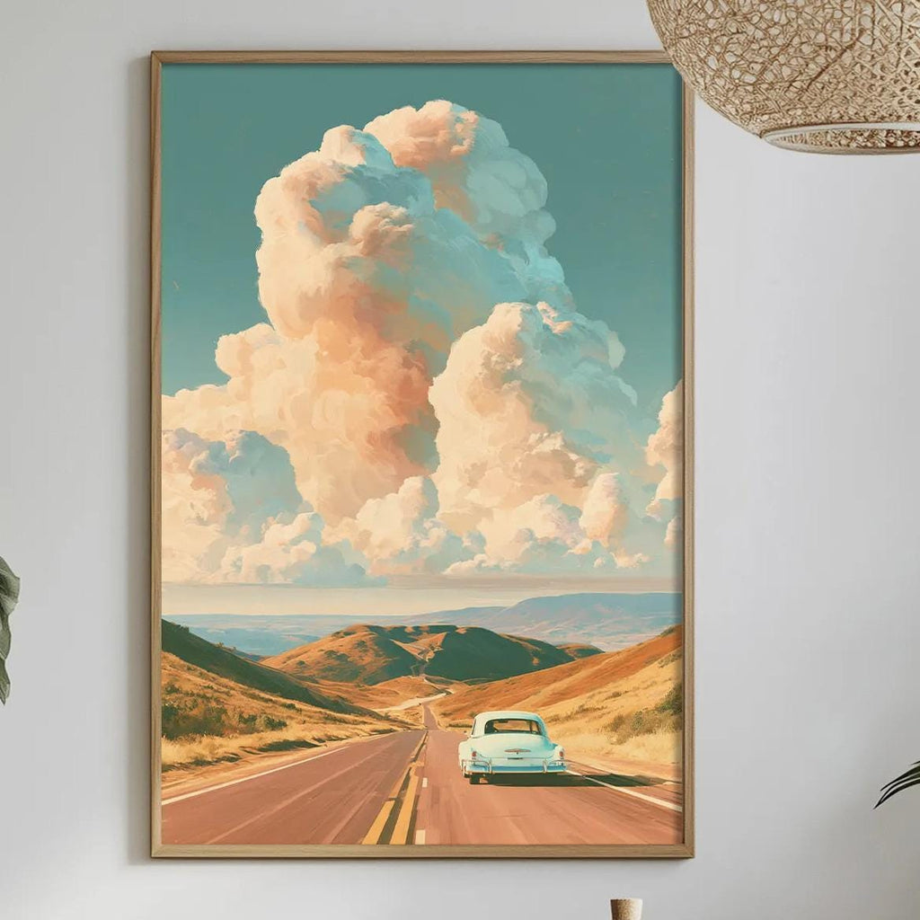 a framed painting of a car driving on a road through a scenic landscape, with a large cloud formation in the sky above. The painting is hung on a wall above a dining table with various decorative items and plants.