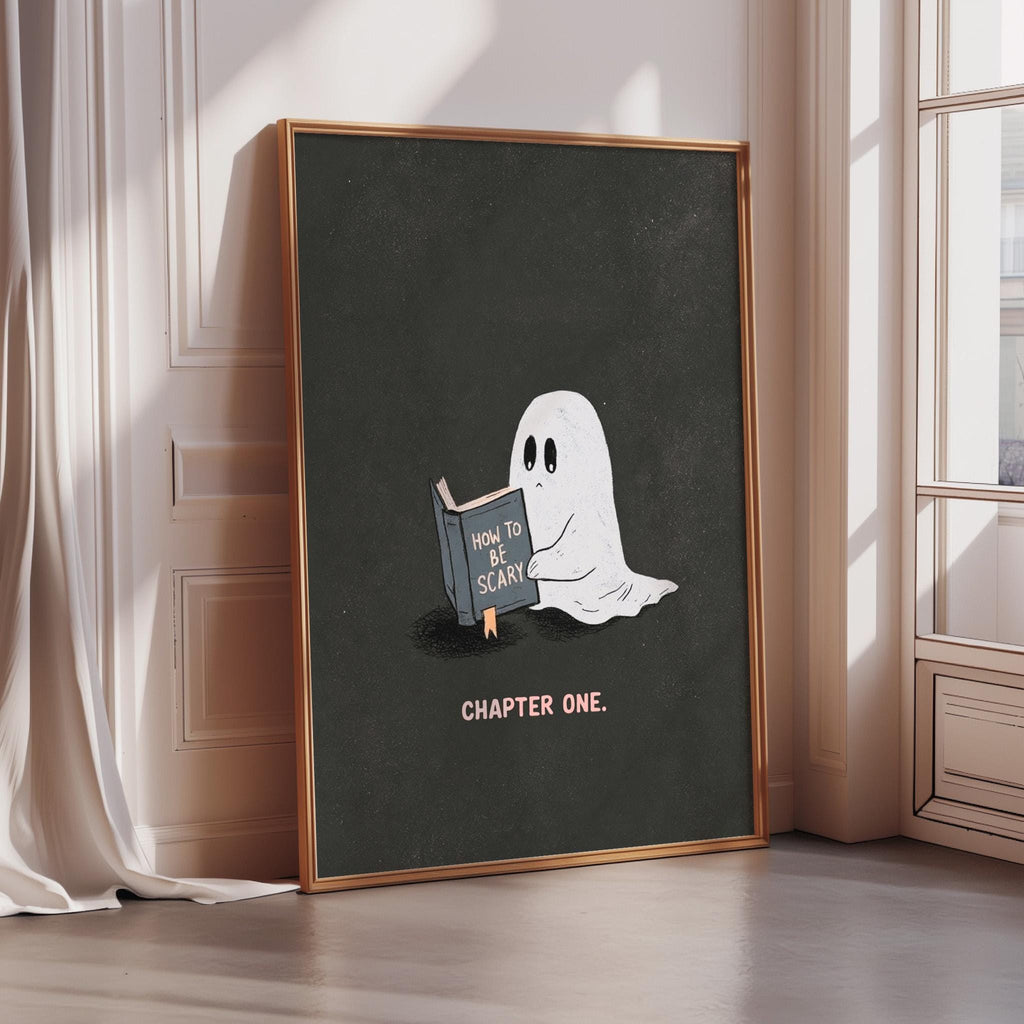a framed poster with a ghost reading a book titled "How to be scary" and the text "CHAPTER ONE."