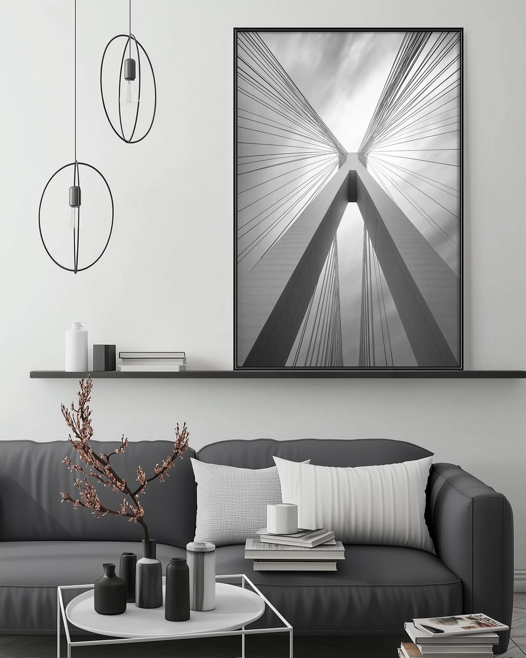 a modern living room with a gray sofa, a coffee table, and a large black and white photograph of a bridge with a striking design hanging on the wall.