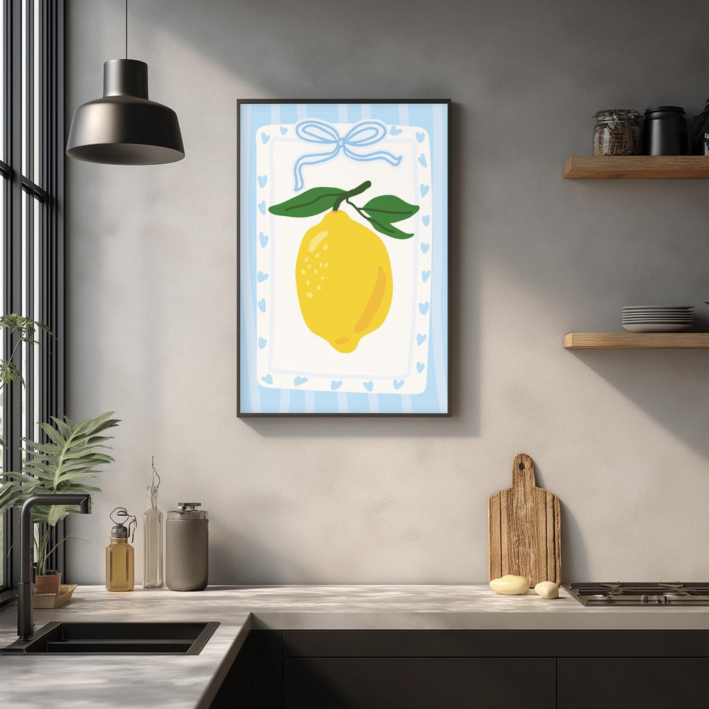 a kitchen counter with a framed picture of a lemon hanging on the wall above it. The counter has various kitchen items, such as a cutting board, a soap dispenser, and a bottle.
