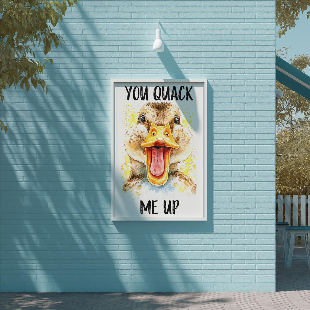 A framed poster with a duck's face and the text "YOU QUIACK ME UP" is displayed on a blue brick wall.