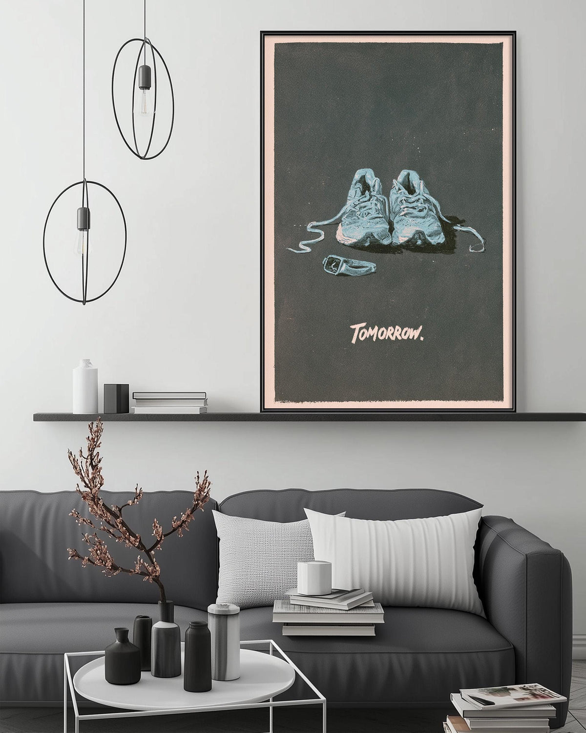 a gray couch with a coffee table in front of it, and a framed poster of a pair of shoes on the wall above the couch.
