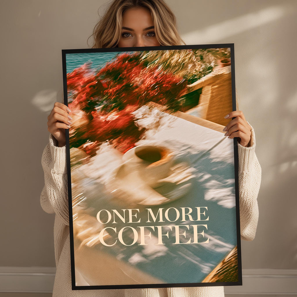 A woman holding a framed poster with a blurred image of a coffee cup and flowers.