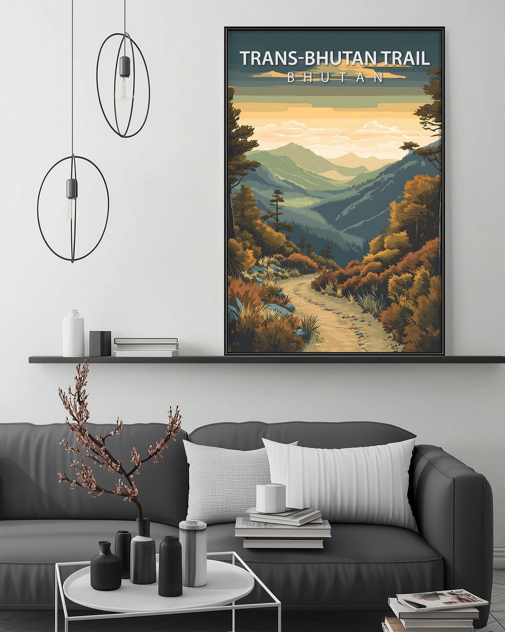 a large framed poster of a scenic mountain landscape with a winding path, hanging on a wall above a gray couch with a coffee table in front of it.