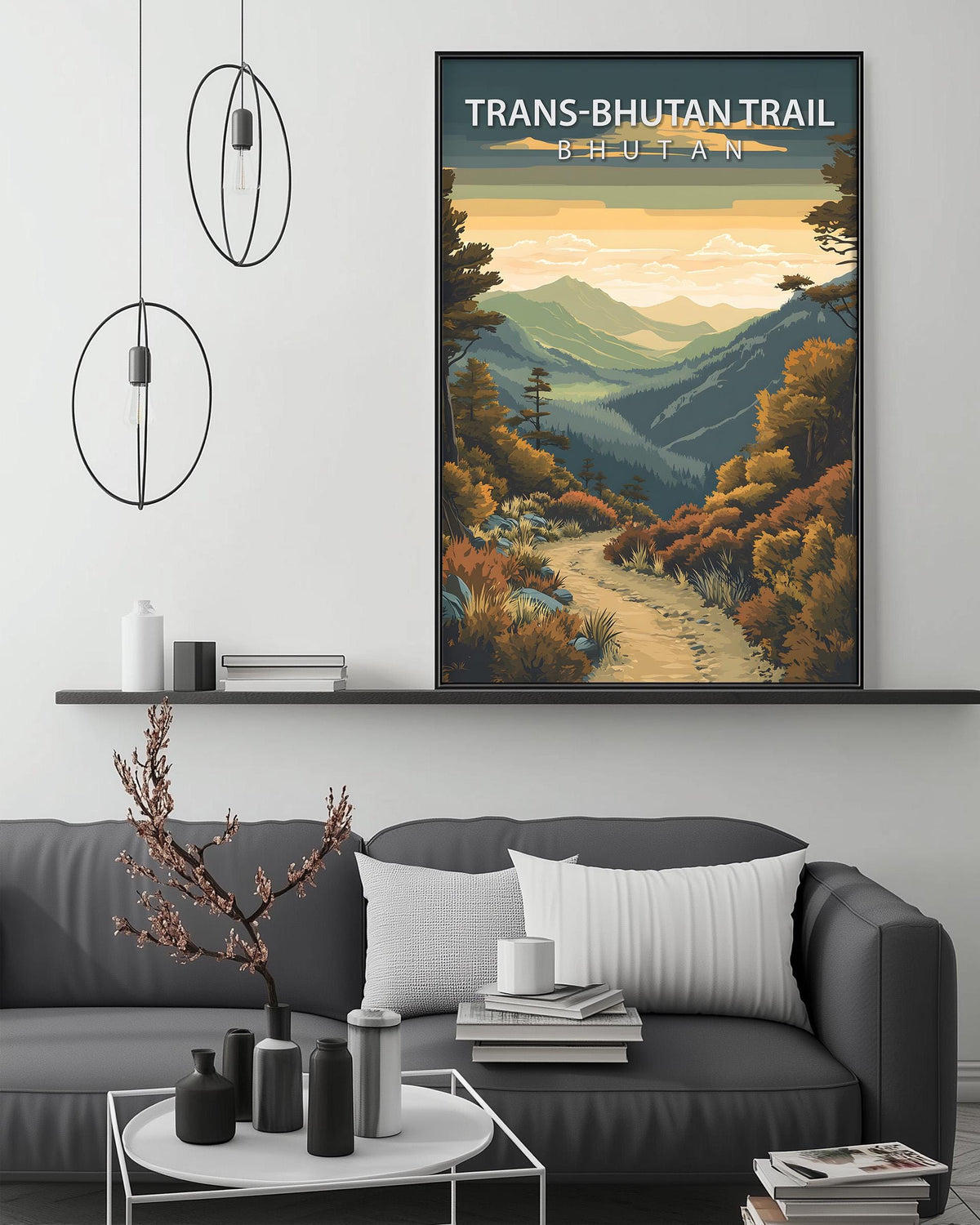 a large framed poster of a scenic mountain landscape with a winding path, hanging on a wall above a gray couch with a coffee table in front of it.