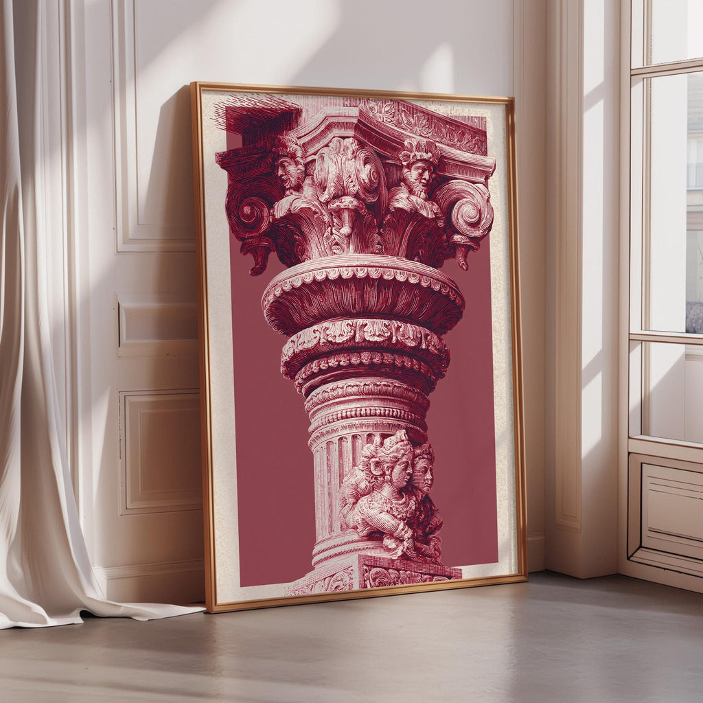A large, ornate, and intricately decorated column or pillar is displayed in a framed artwork, which is placed on a wall in a room with a window.