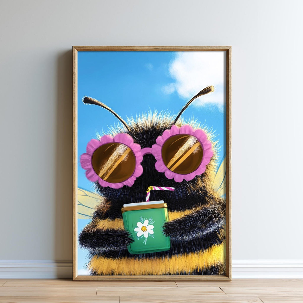 A framed illustration of a bee wearing sunglasses and holding a drink, with a flower on the drink.