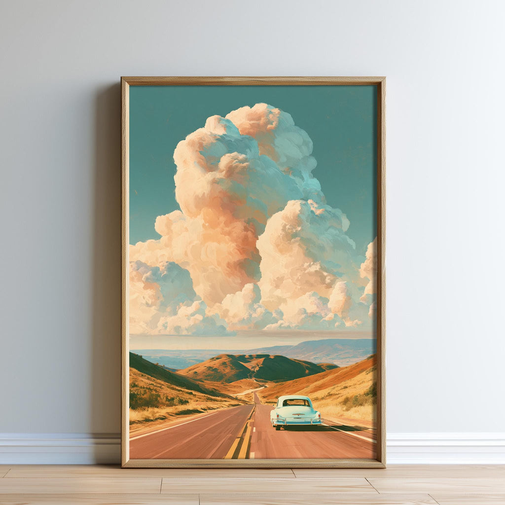 A framed painting depicting a scenic road leading through a mountainous landscape with a vintage car driving on the road.