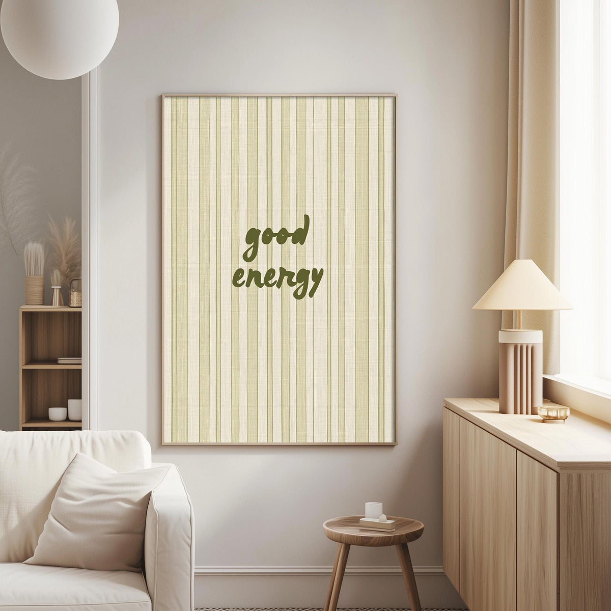 a living room with a white sofa, a wooden side table, and a framed poster with the text "good energy" on the wall.