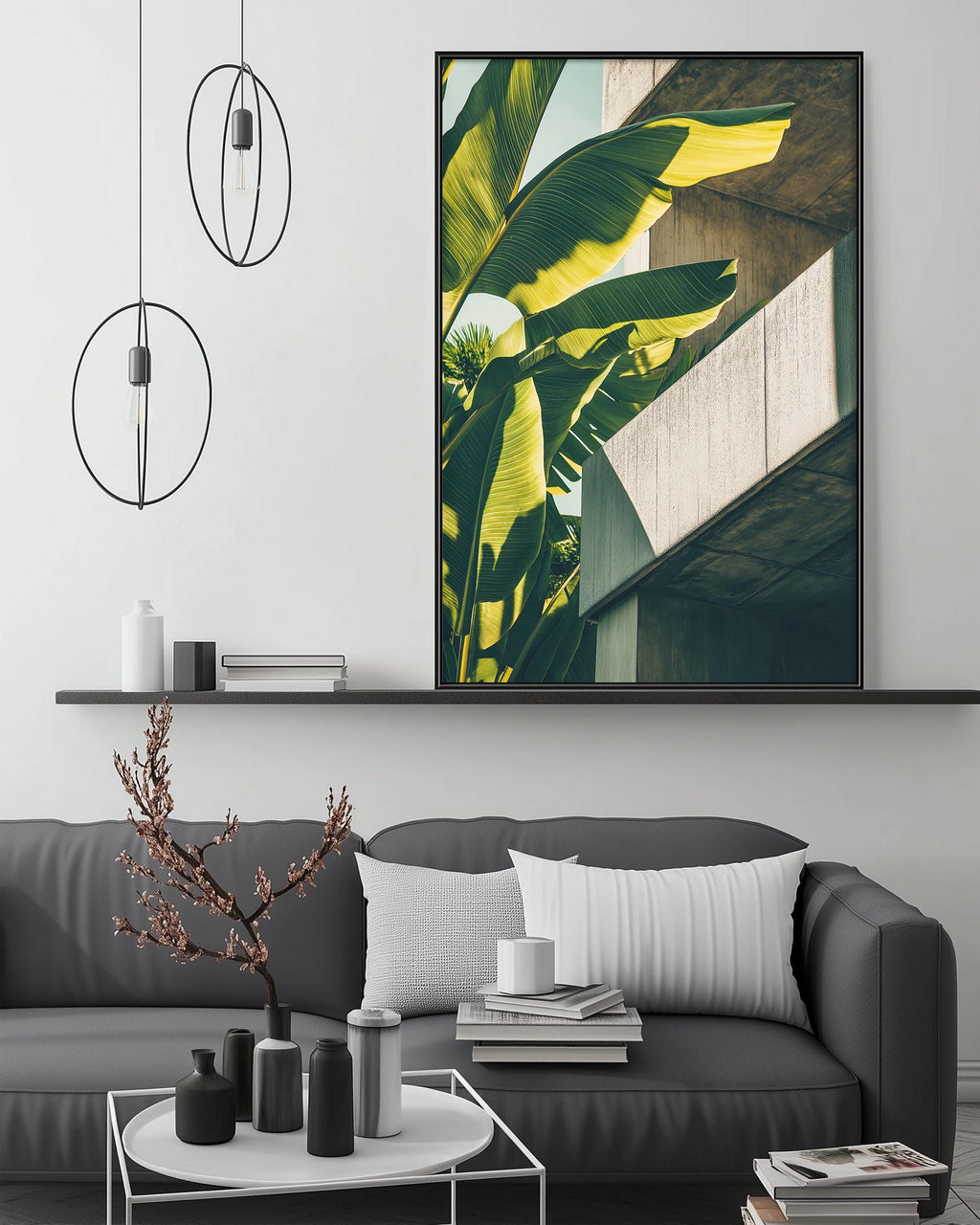 a modern living room with a gray sofa, a coffee table, and a large framed print of a tropical plant on the wall.