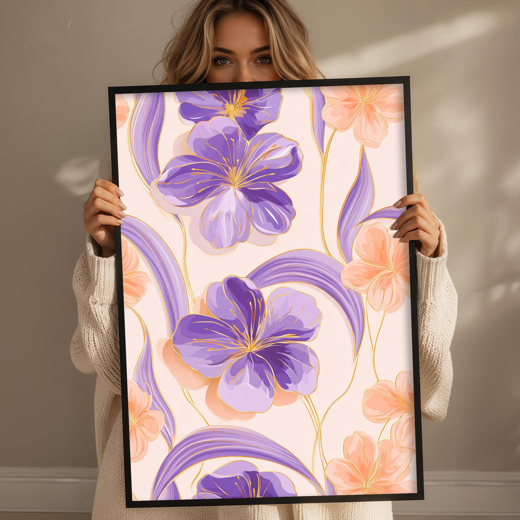 A woman is holding up a framed print with a floral design featuring purple and orange flowers.