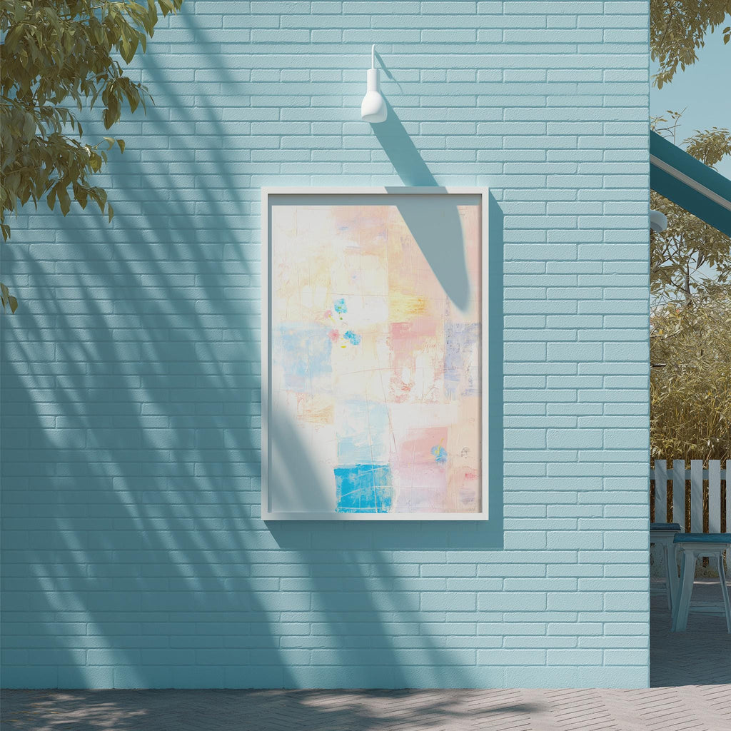 a blue brick wall with a framed abstract painting hanging on it. The painting has a vibrant mix of colors and shapes, creating a visually striking contrast against the blue background. The painting is framed in a white border, adding a touch of elegance to the overall composition. The wall is situated next to a tree, providing a natural element to the scene.