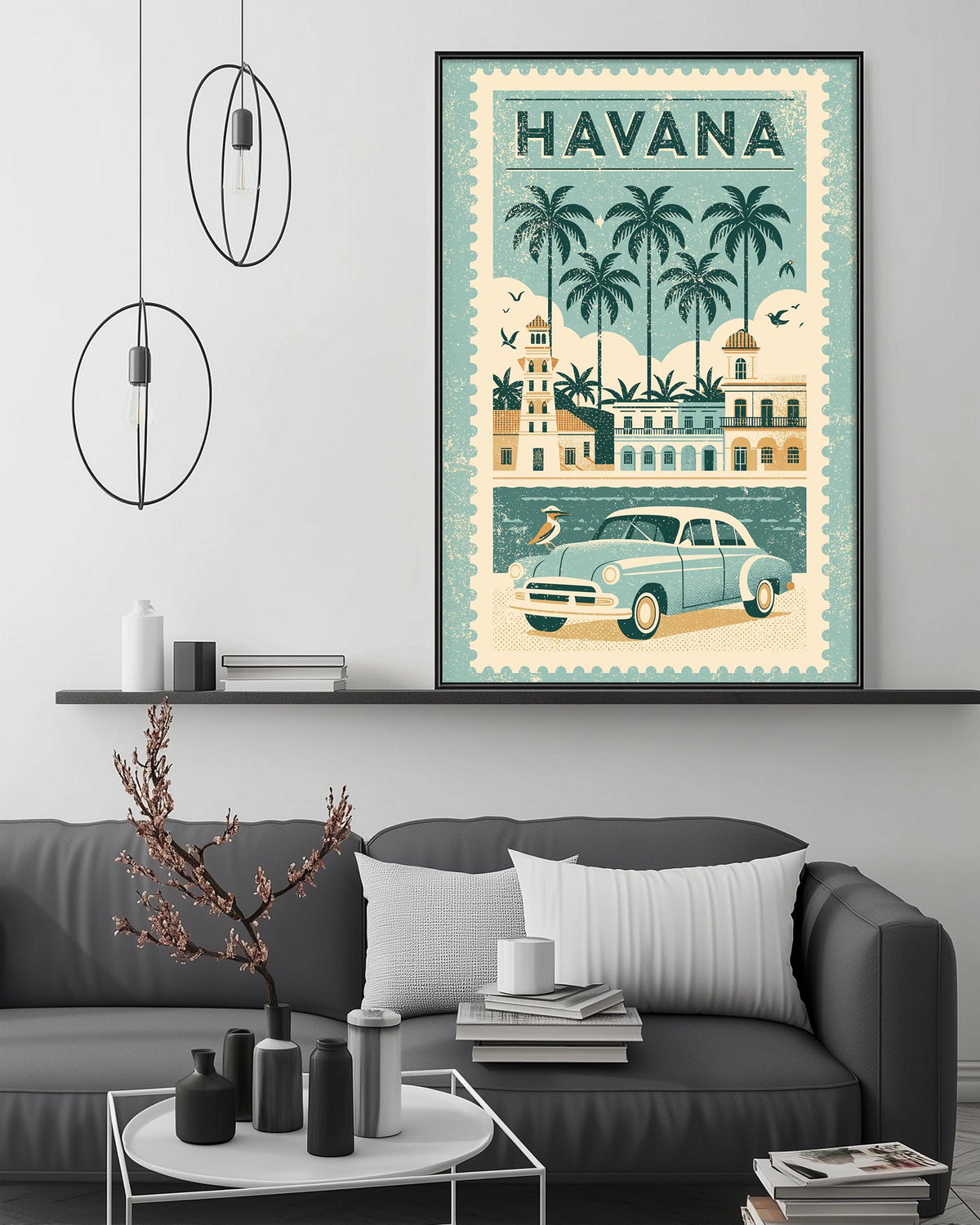 a framed poster of a vintage car and palm trees, hanging on a wall above a gray couch in a living room setting.
