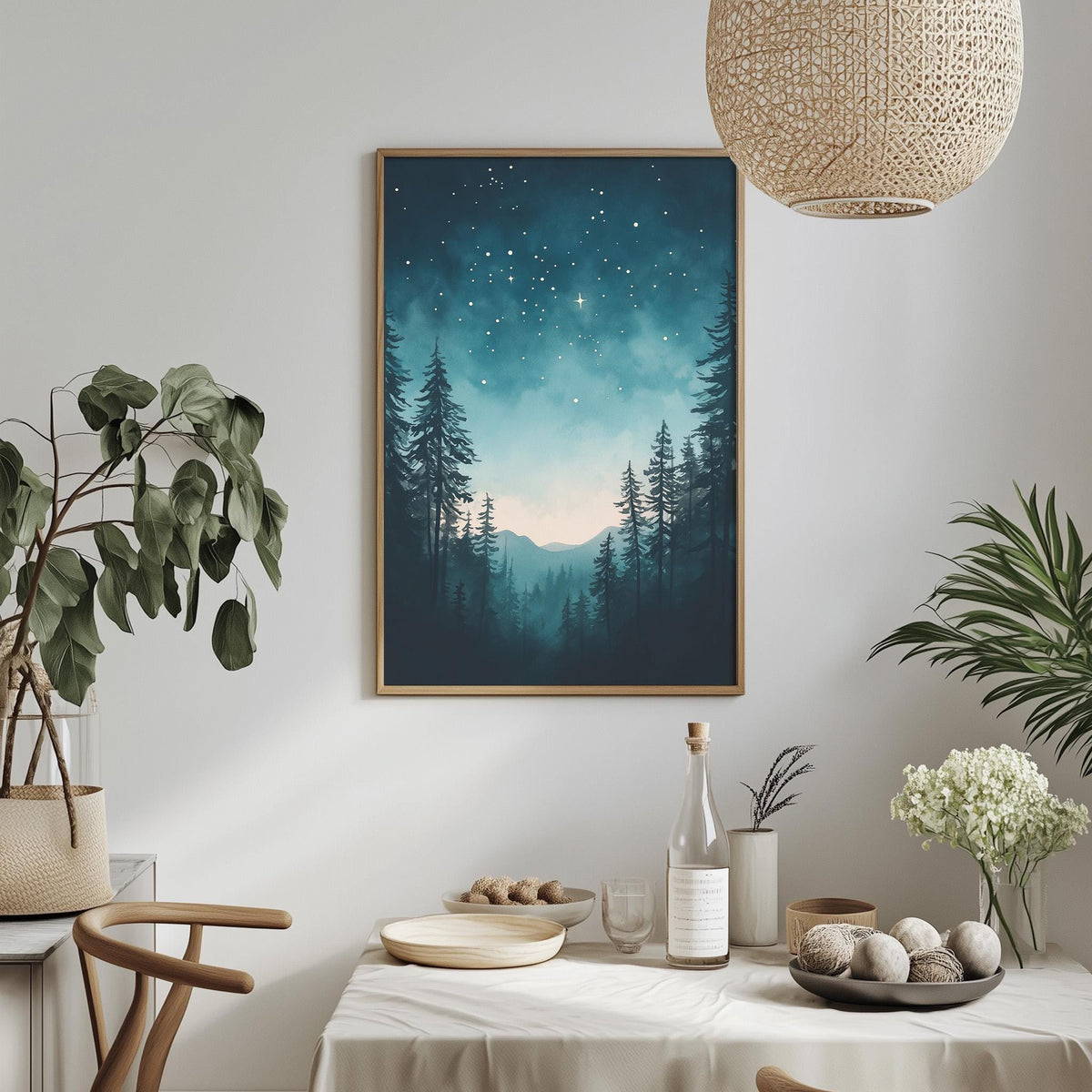 a serene indoor setting with a framed picture of a forest scene hanging on the wall, a table set with various items, and a potted plant nearby.
