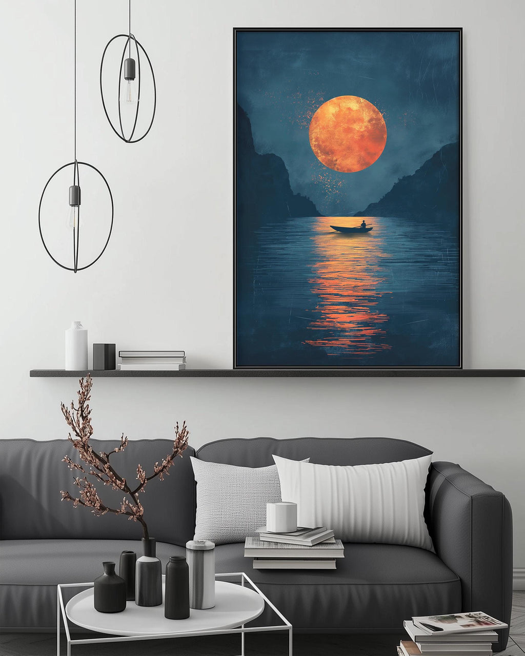 a large painting of a boat on a lake at night, with a large orange moon in the sky. The painting is hanging on a wall above a gray couch, which has a coffee table in front of it. The room has a minimalist and modern design, with a few decorative items and lighting fixtures.