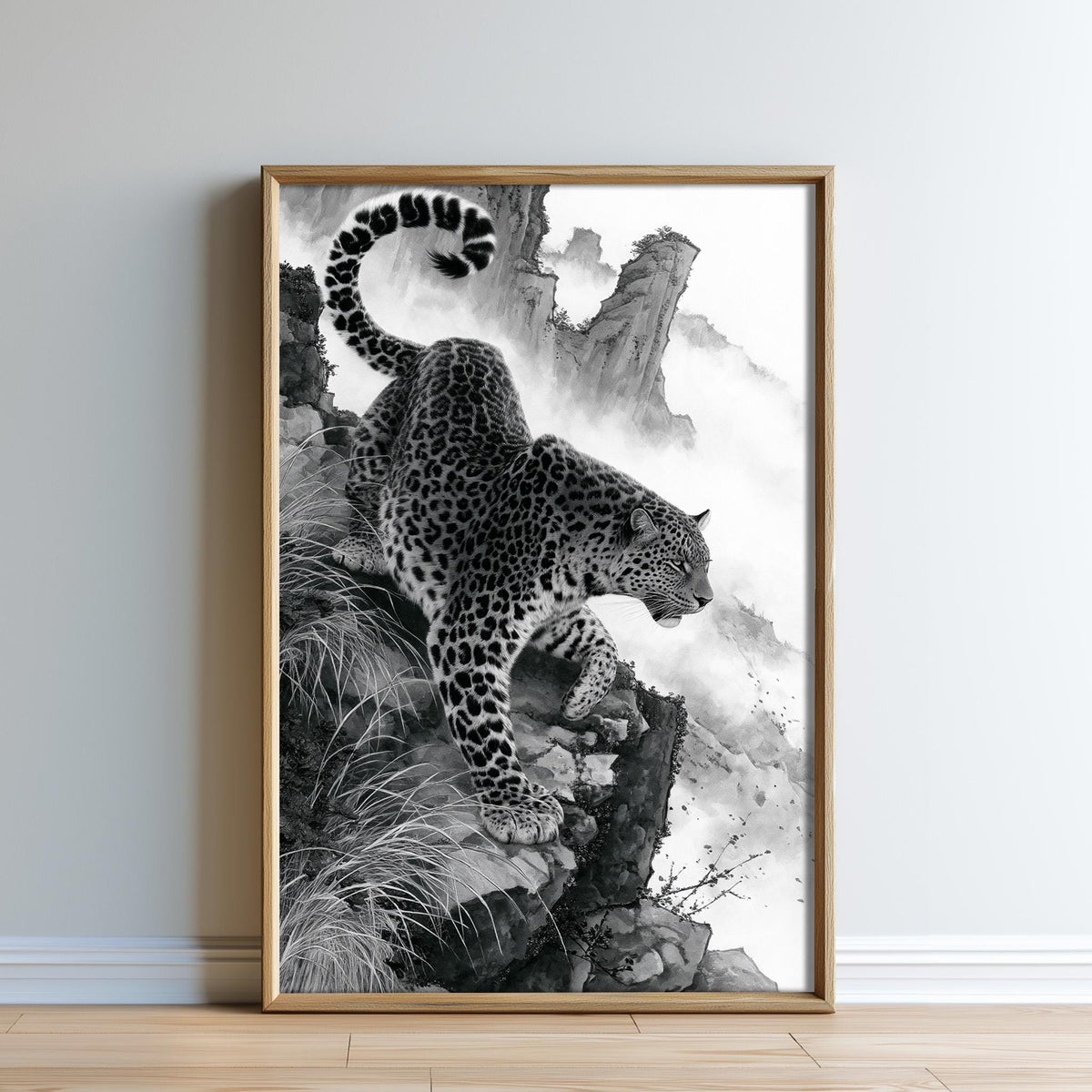 A leopard is captured in a striking black and white photograph, poised on a rocky cliff with its tail curled upwards.