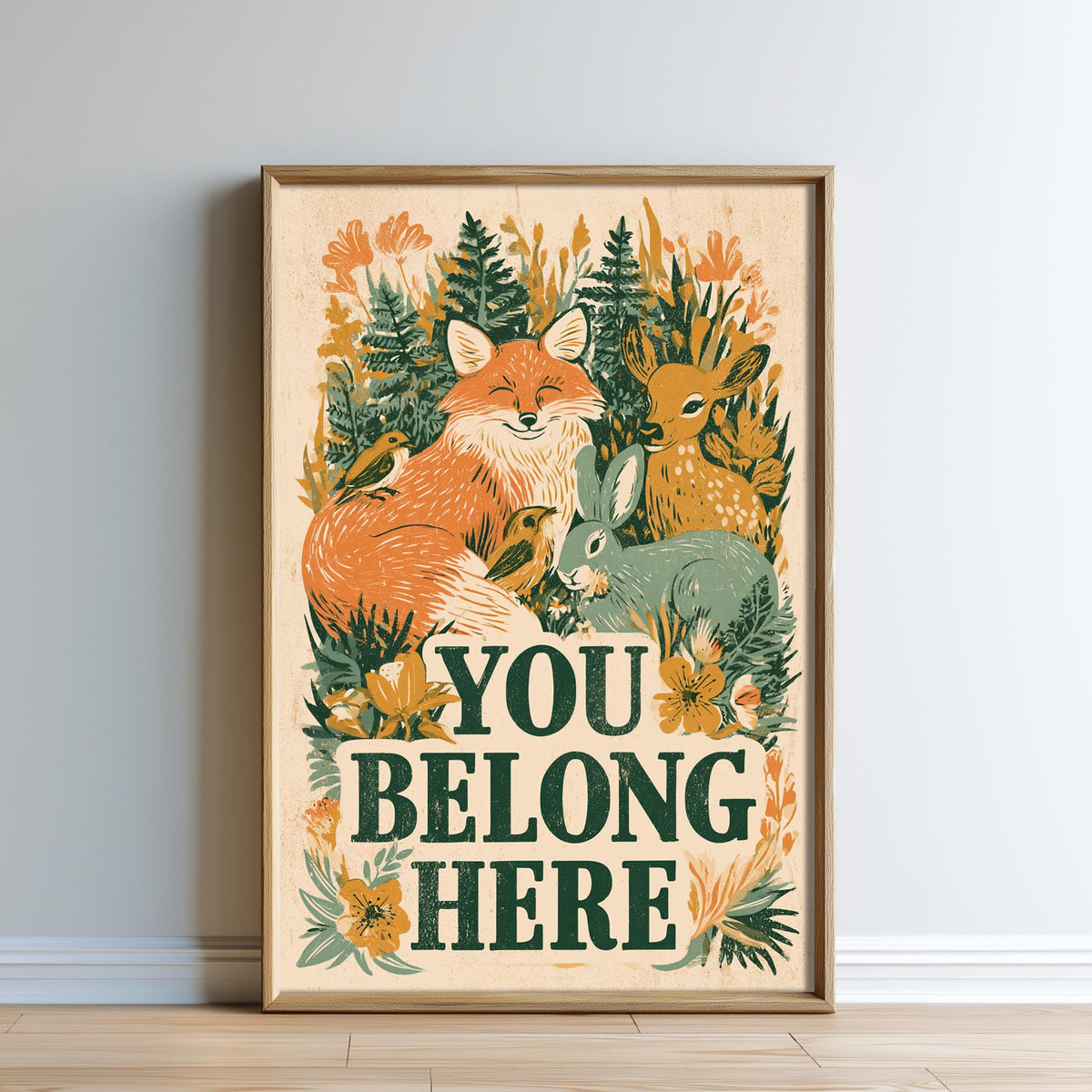The image is a framed poster with a vibrant illustration of various animals, including a fox, rabbit, and deer, surrounded by lush greenery and flowers. The text "YOU BELONG HERE" is prominently displayed in the center of the poster.