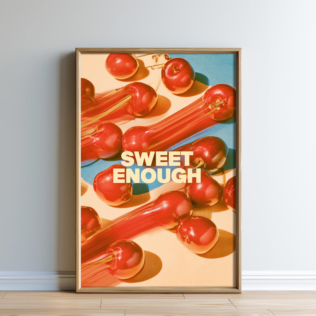 The image is a framed poster with a vibrant display of red apples arranged in a visually appealing manner. The phrase "SWEET ENOUGH" is prominently displayed in the center of the poster, creating a striking contrast against the colorful background.