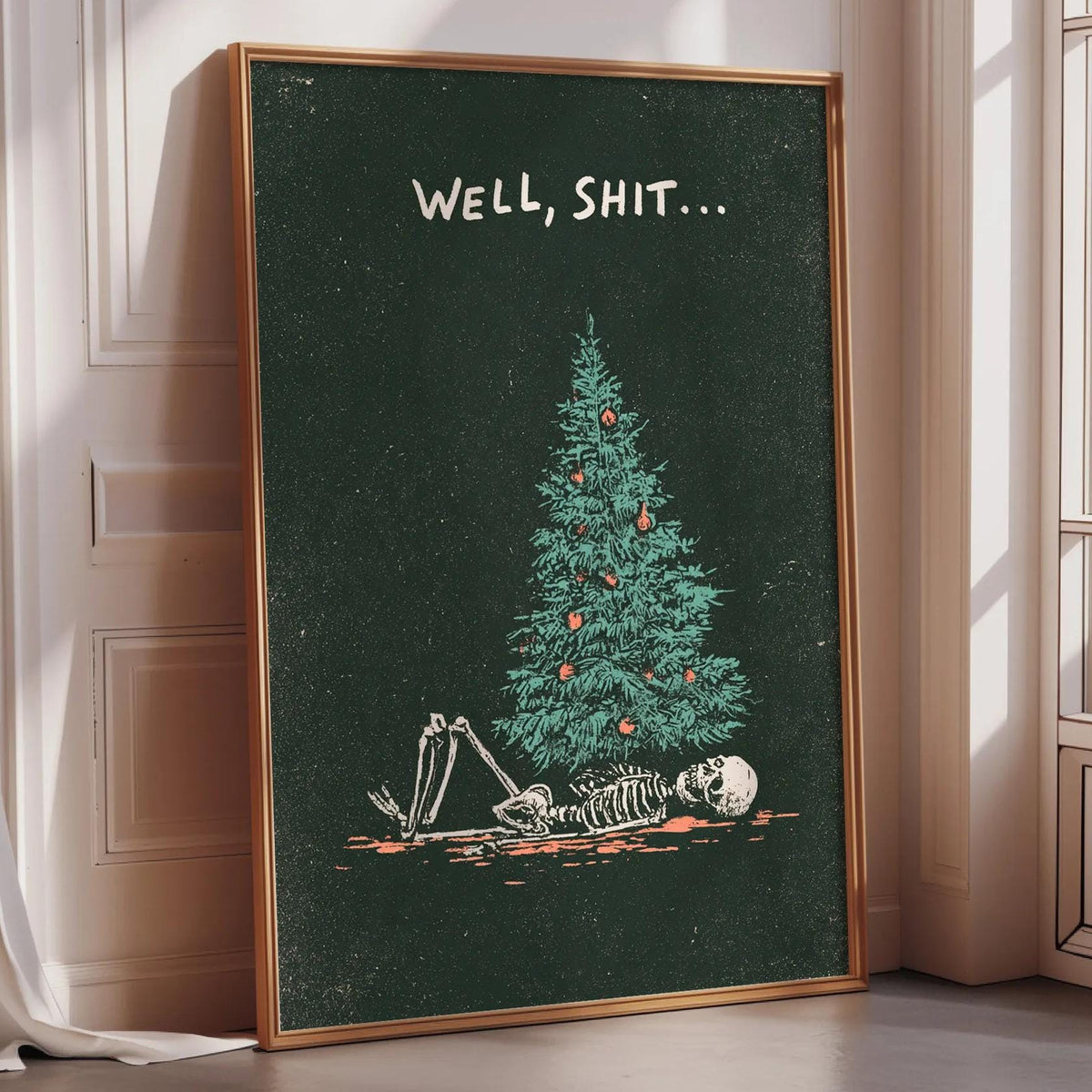 a framed poster with a skeleton lying on the ground in front of a Christmas tree, with the text "WELL, SHIT..." displayed above the skeleton.
