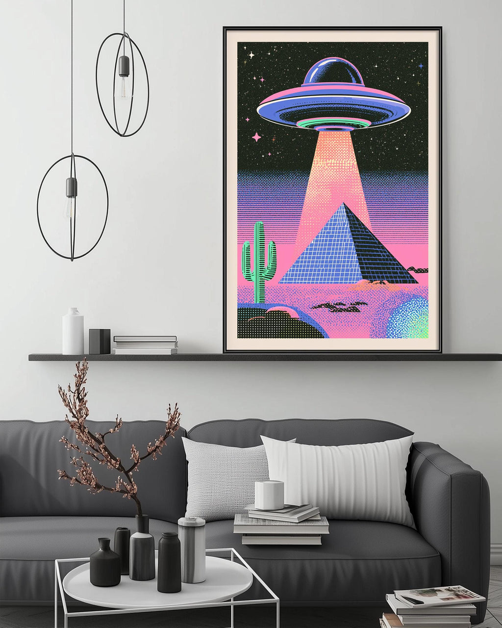 a large, colorful poster of an alien spacecraft hovering over a desert landscape with a pyramid and cactus in the background. The poster is hanging on a wall above a gray couch, which has a coffee table in front of it. The room has a minimalist and modern design, with a few decorative items and lighting fixtures.
