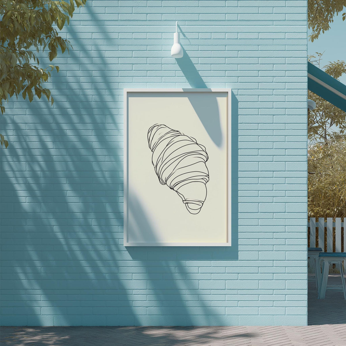 a blue brick wall with a framed illustration of a croissant hanging on it.