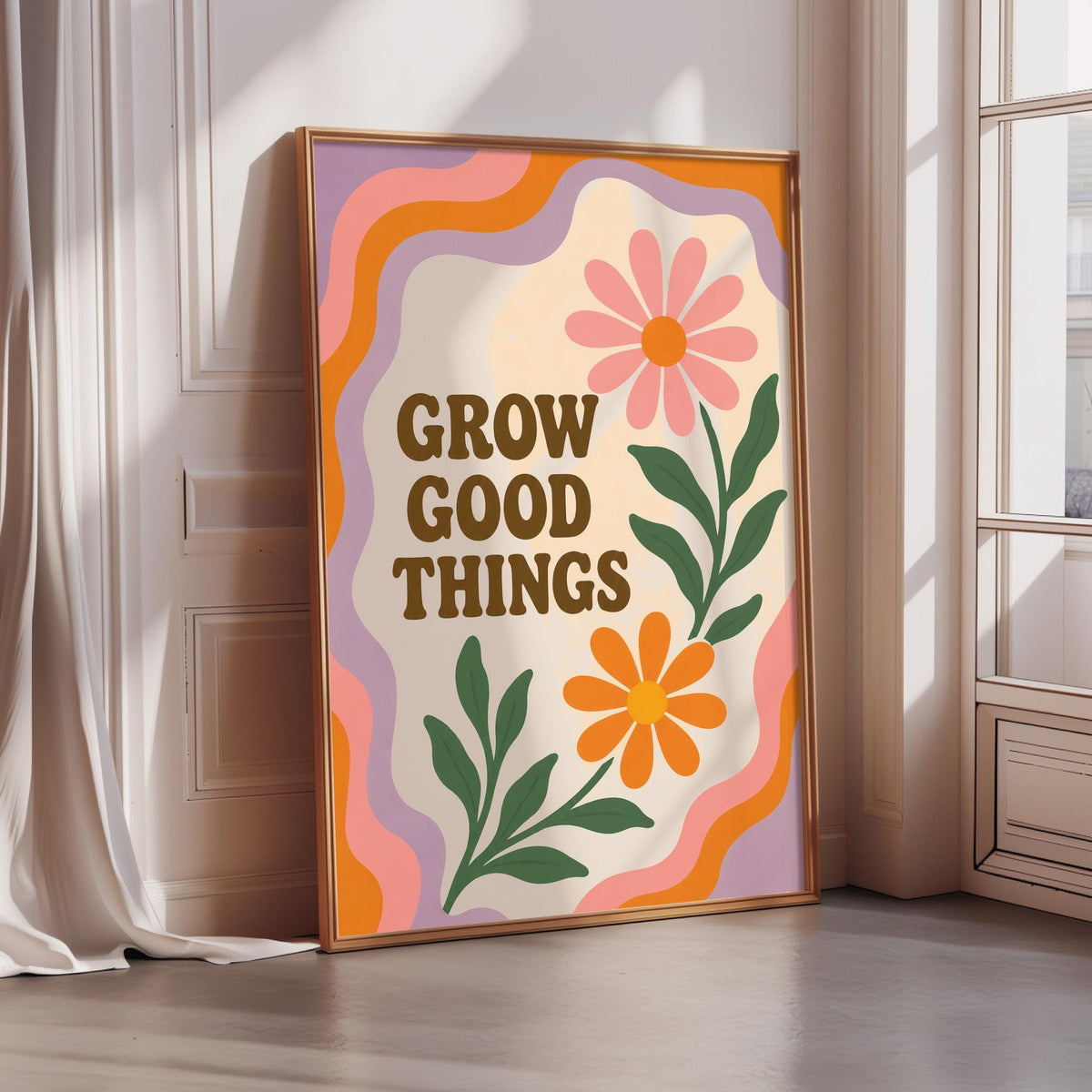 A framed poster with a colorful design featuring flowers and the text "GROW GOOD THINGS" is displayed in a room with a window.