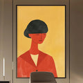 a modern and stylish office space with a large abstract painting of a woman's face on the wall, a wooden desk with a chair, and built-in bookshelves.