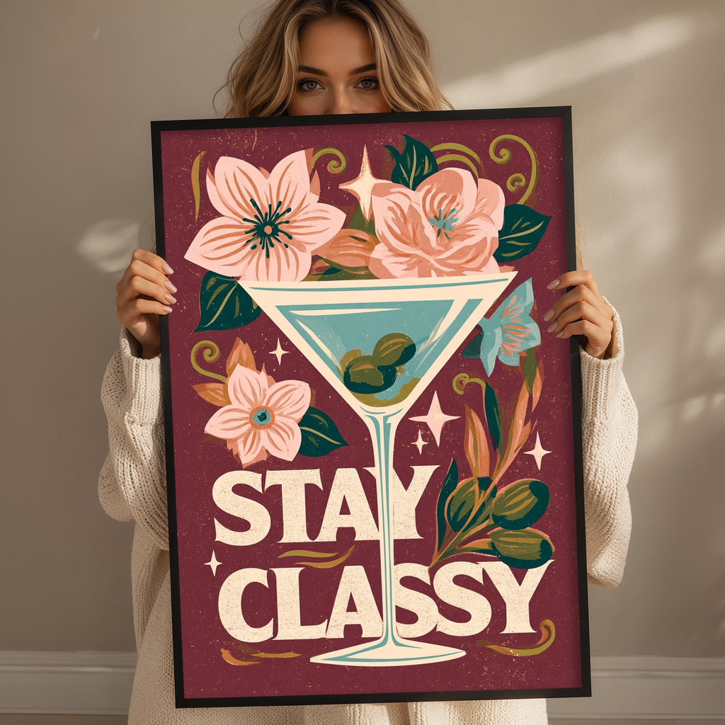 A woman holding a framed poster with a floral design and the text "STAY CLASSY" on it.