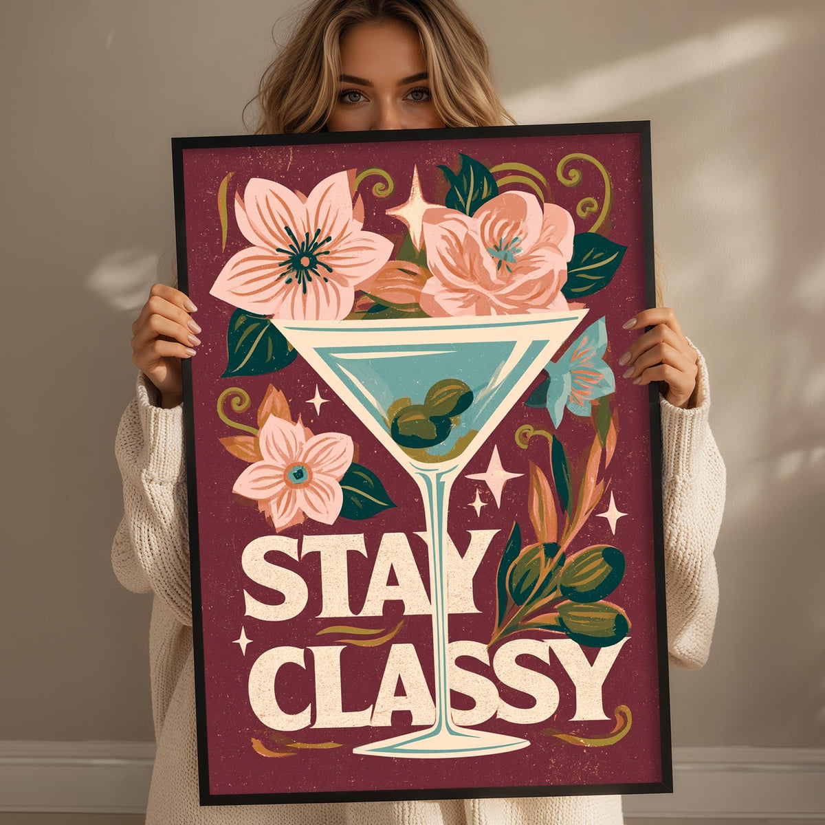 A woman holding a framed poster with a floral design and the text "STAY CLASSY" on it.