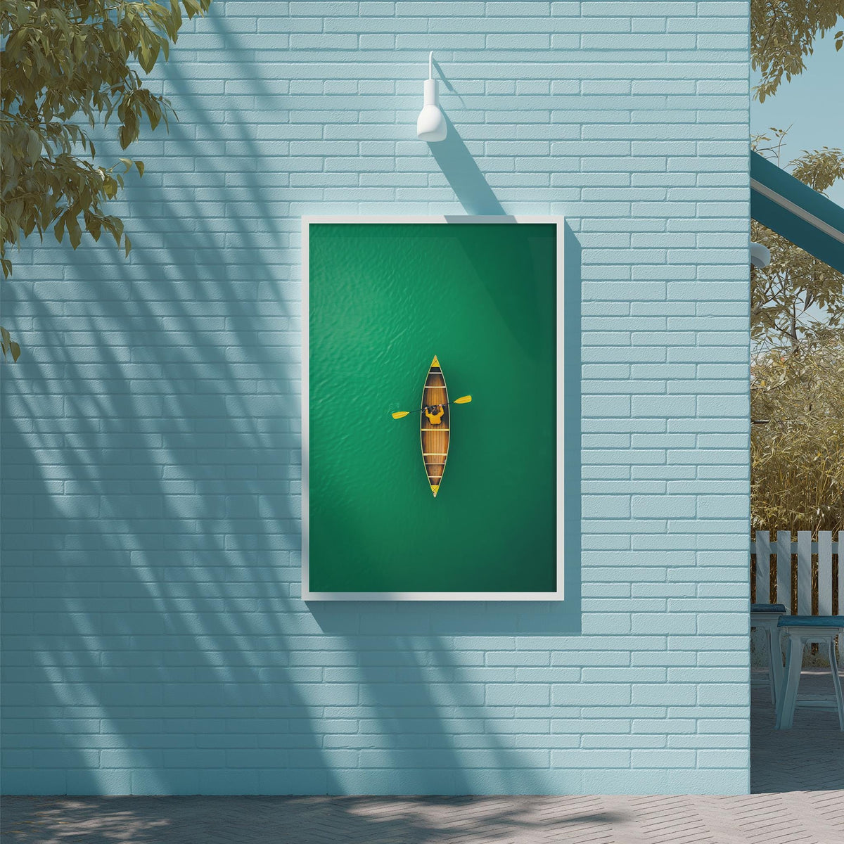 a green wall with a white frame, on which there is a framed image of a canoe on a body of water.