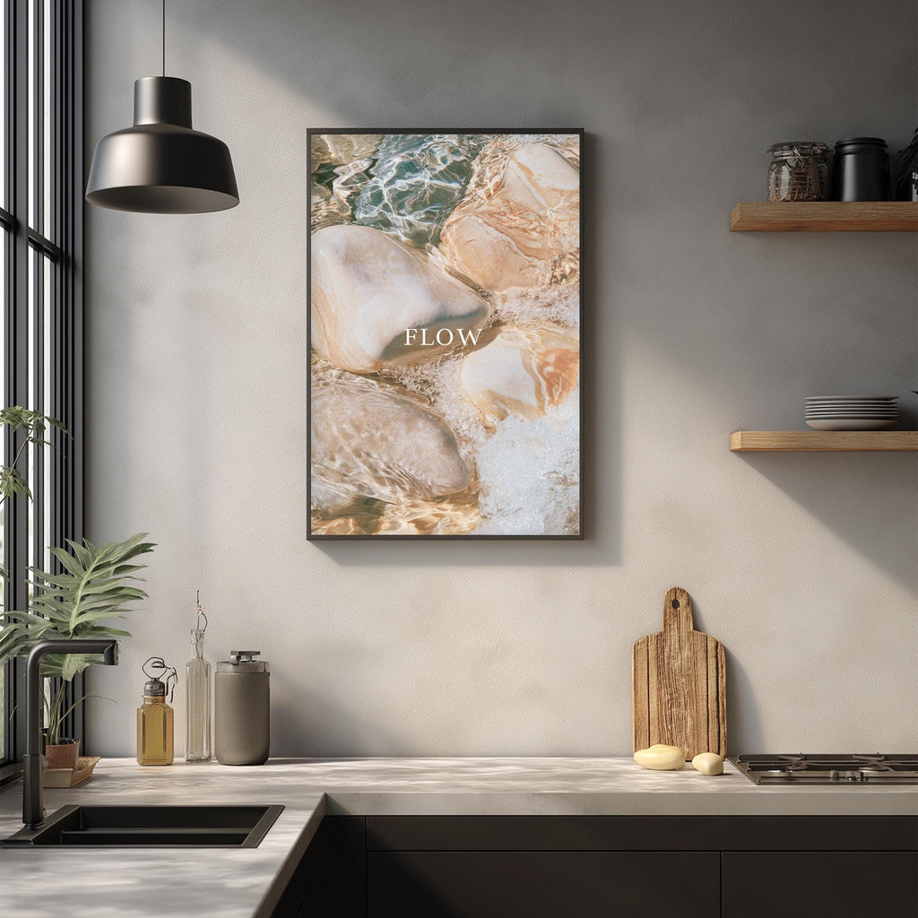a kitchen counter with various items such as a cutting board, a soap dispenser, and a plant. Above the counter, there is a framed picture hanging on the wall with the word "FLOW" written on it.
