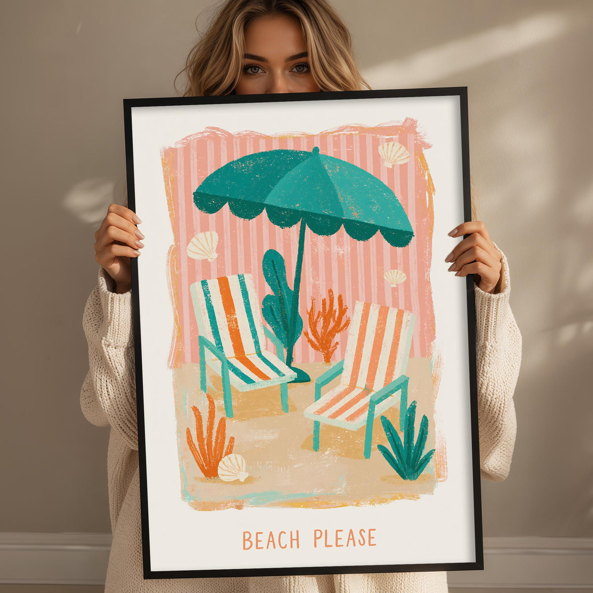 A woman holding a framed print with a beach scene, including a green umbrella, striped chairs, and plants.
