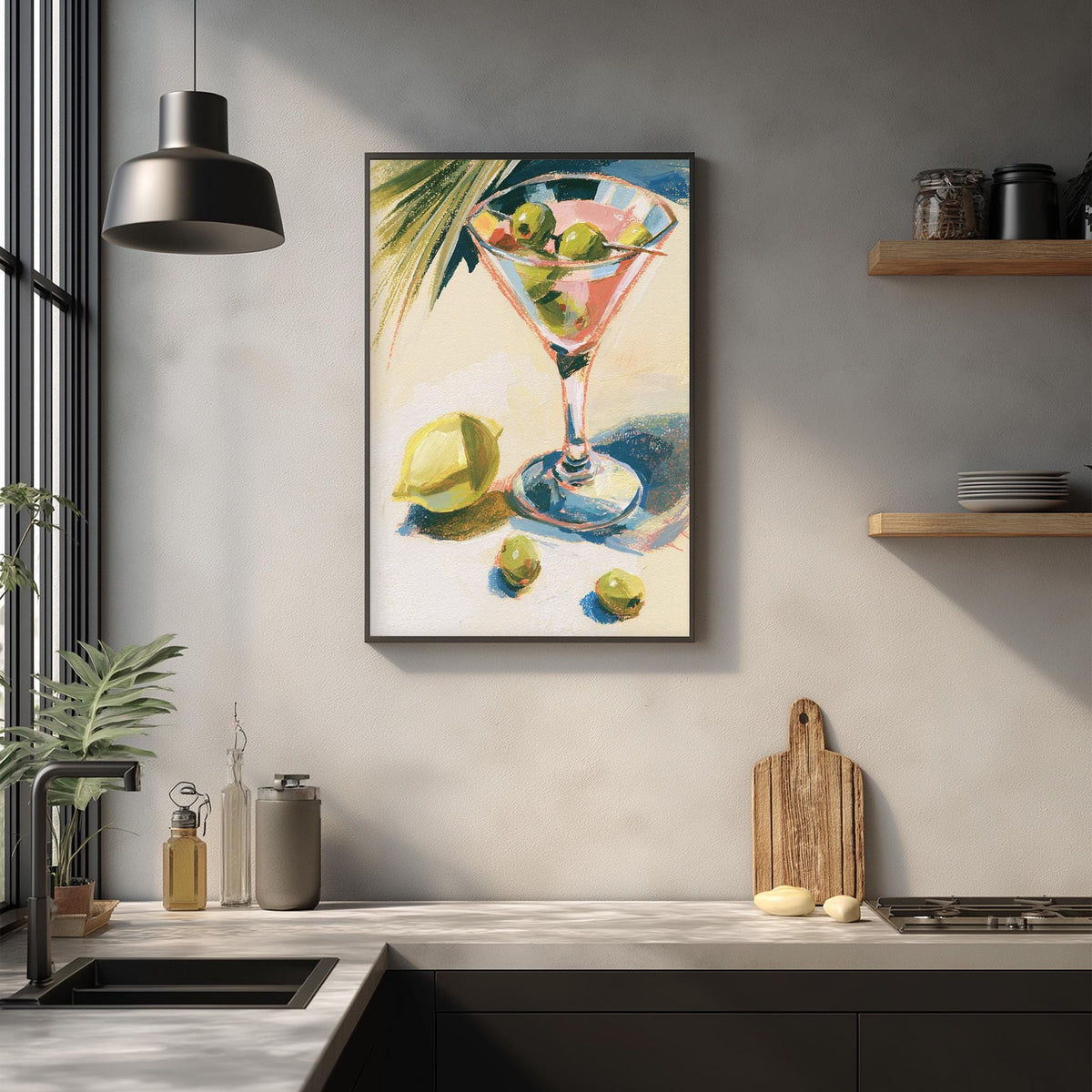 a kitchen counter with a framed painting of a martini glass filled with olives and a lemon on it, along with a wooden cutting board and other kitchen items.