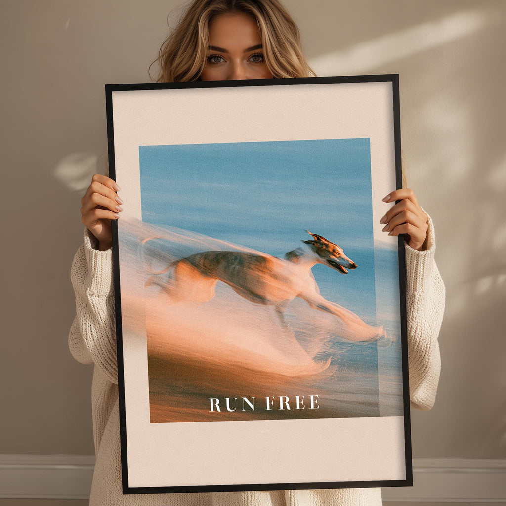 A woman holding a framed picture of a dog running in the air.