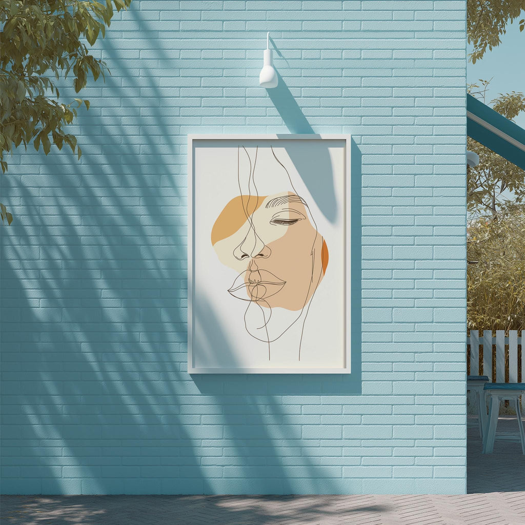 a framed abstract drawing of a face on a blue brick wall, with a white light fixture above it.