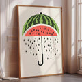 A framed poster depicting a watermelon with a green stem and a red interior, with water droplets falling from the top.