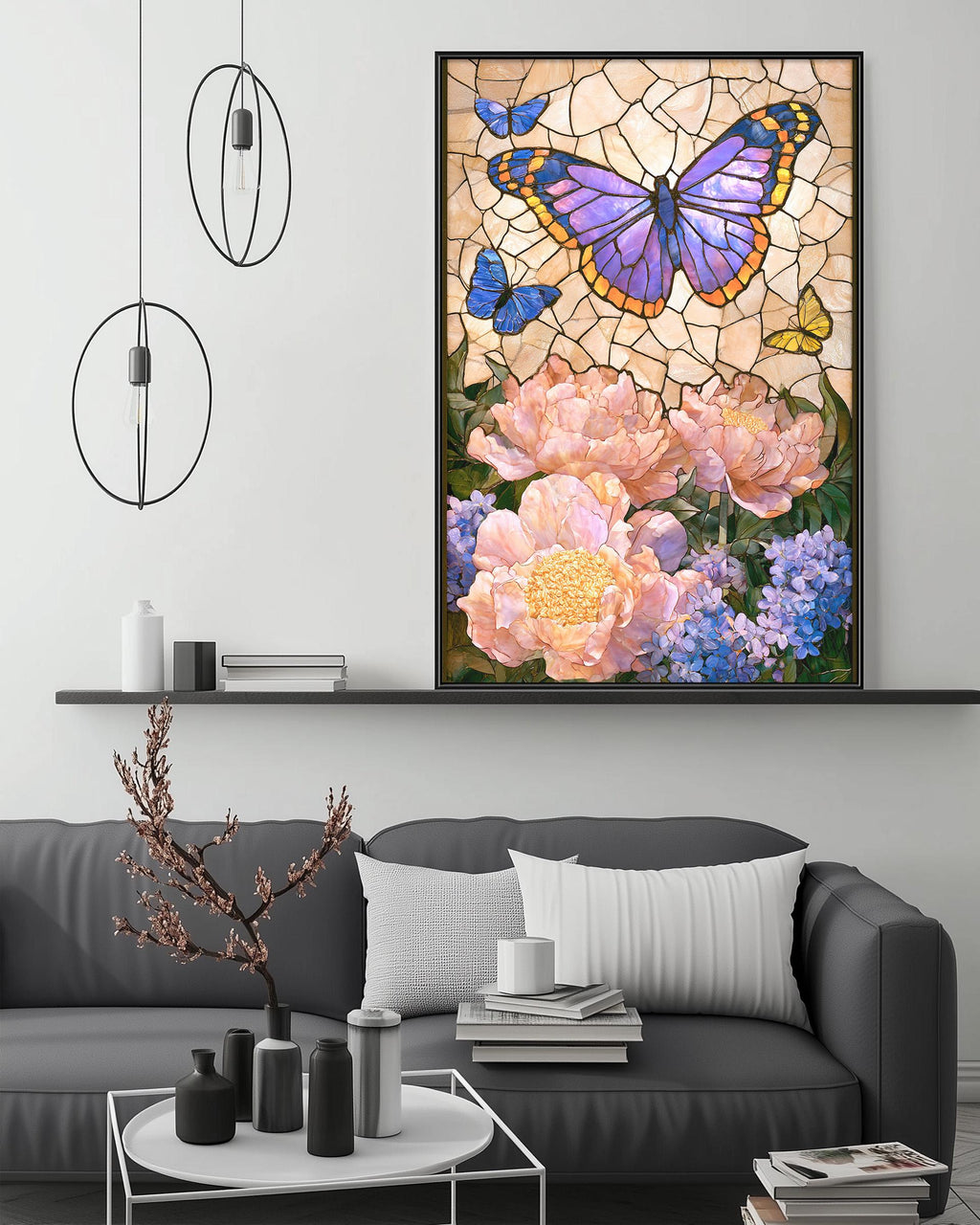a large framed painting of a butterfly surrounded by flowers, including pink peonies and blue irises, hanging on a wall above a gray couch in a living room setting.
