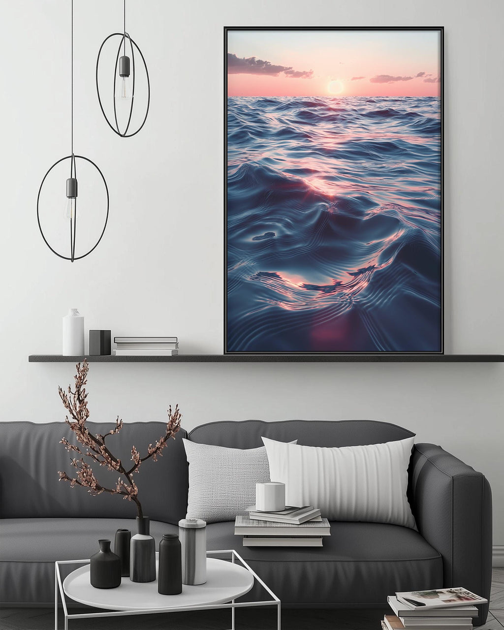 a large, framed picture of a serene ocean scene with a sunset, hanging above a gray couch in a modern living room setting.
