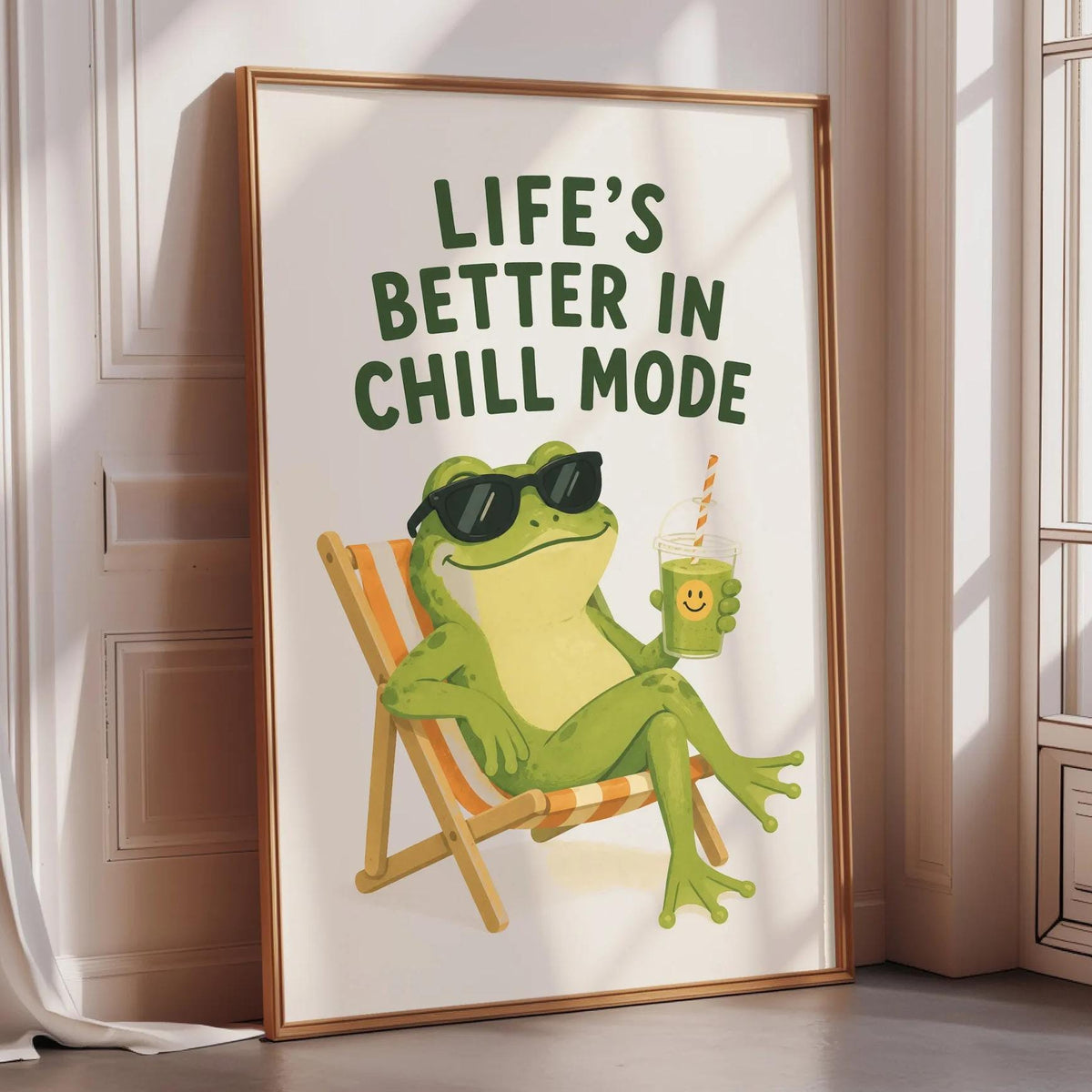 A framed poster with a cartoon frog sitting in a chair, wearing sunglasses and holding a drink, with the text "Life's better in chill mode" written above the image.