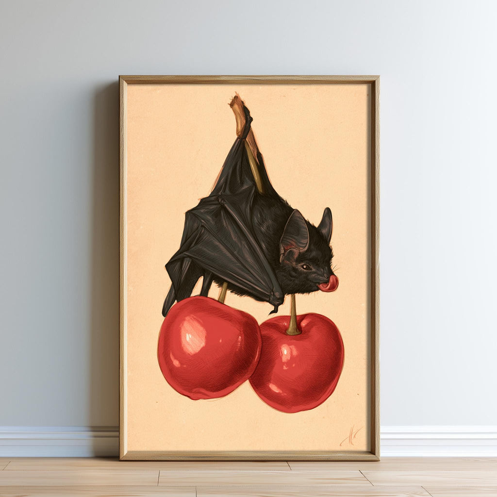 A framed illustration of a bat perched on two red cherries.