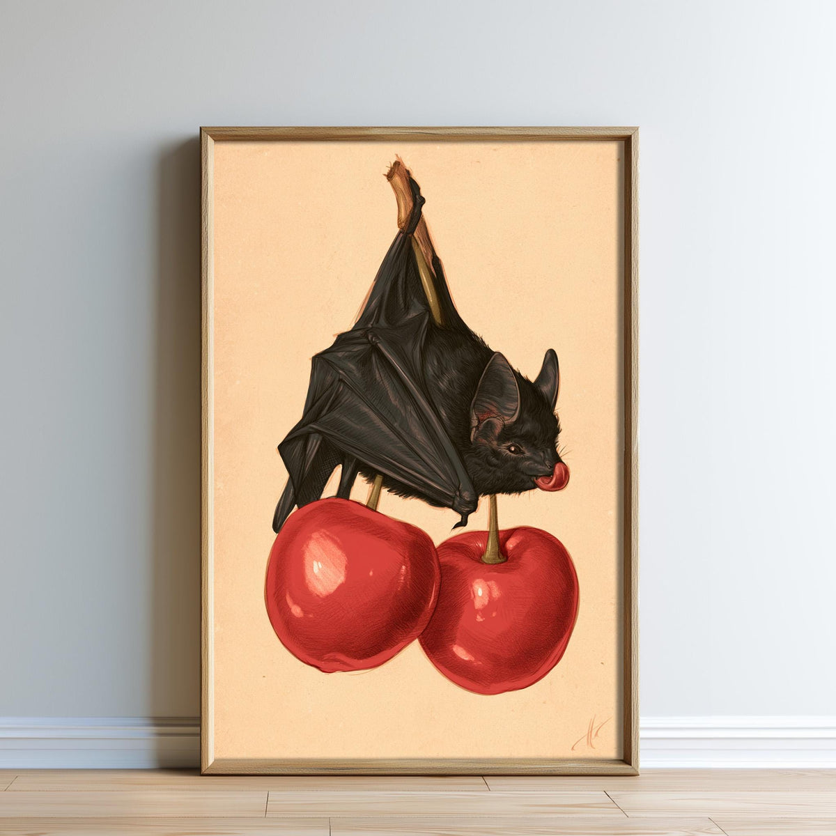 A framed illustration of a bat perched on two red cherries.