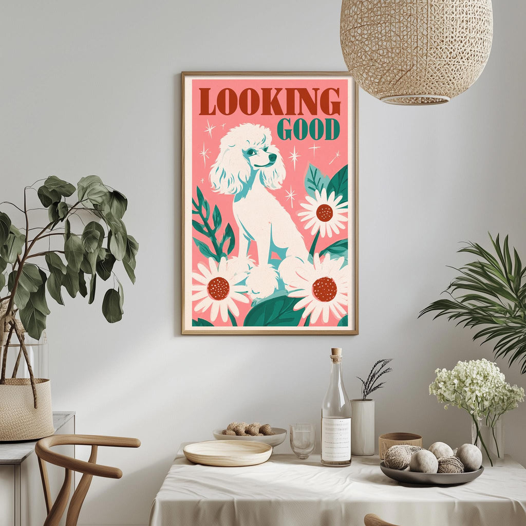 a framed poster of a poodle with a pink background and floral elements, hanging on a wall above a dining table with various decorative items.