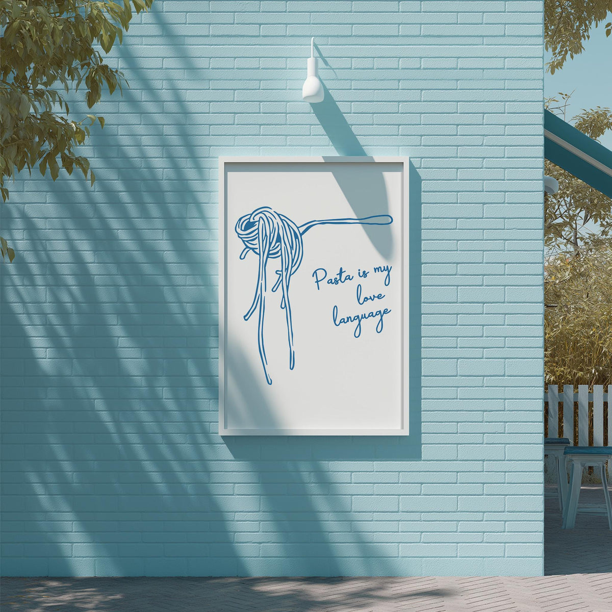 a framed poster with a drawing of spaghetti noodles and the text "Pasta is my love language" on a blue brick wall.
