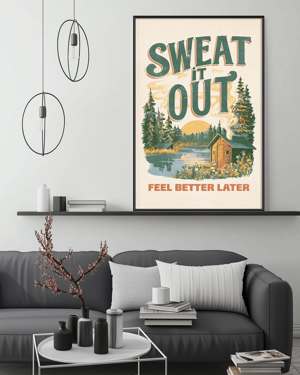 a cozy living room with a gray couch, a coffee table, and a framed poster on the wall. The poster has a forest scene and the text "SWEAT IT OUT" and "FEEL BETTER LATER".