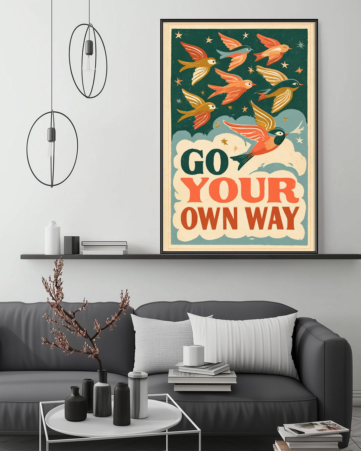 a poster with a bird illustration and the text "Go your own way" displayed on a wall above a gray couch with decorative items on it.