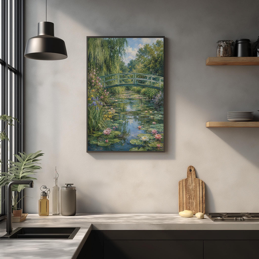 a kitchen counter with a framed painting of a garden scene hanging above it. The painting depicts a tranquil garden with a pond, surrounded by lush greenery and a bridge. The kitchen counter has various items on it, including a cutting board, a bottle, and a vase.