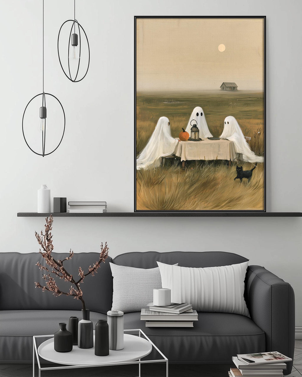 a living room with a gray couch, a coffee table, and a large framed painting depicting three ghostly figures sitting at a table in a field.